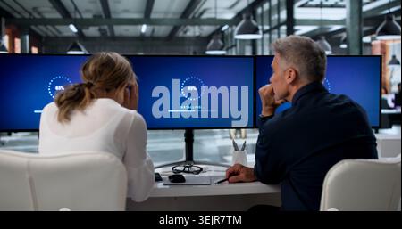 Two IT Specialists Working Together On Updating Slow Computer Systems. Stock Photo