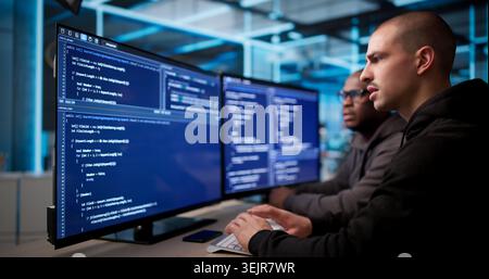 Two Software Engineers Discuss And Develop Secure Business Applications Together. Stock Photo