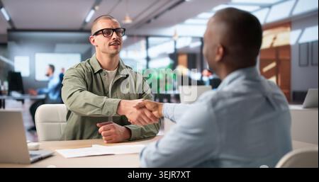 Recruiter And Candidate Shake Hands After Successful Interview In Office. Stock Photo