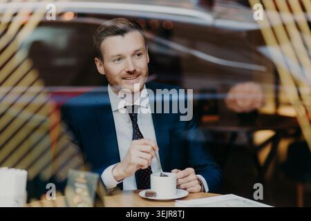 Businessman drinking coffee in cafe during informal business meeting Stock Photo
