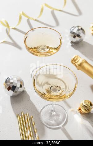 Festive New Year champagne and Christmas silver disco balls on white background. Stock Photo
