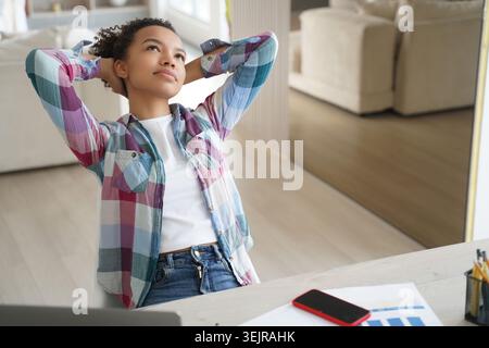 Young black woman taking break at desk while working from home Stock Photo