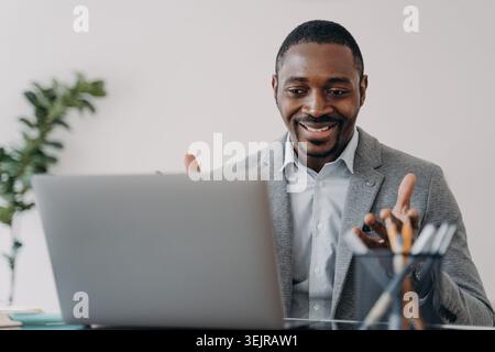 Black businessman on video call using laptop during online meeting in office Stock Photo