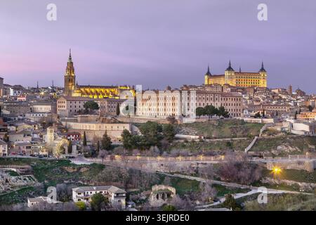 Cathedral and Alcazar of Toledo at sunset, Spain, close-up view. Illuminated medieval architecture under red sky Stock Photo