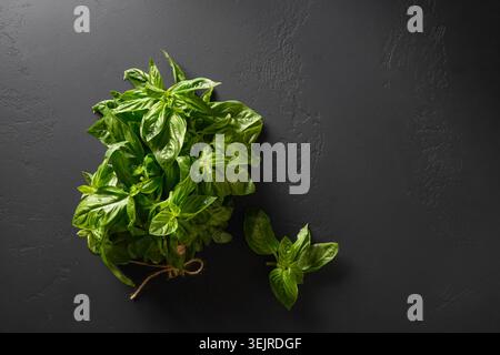 Fresh basil leaves on black background. Summer aroma herbs. View from above. Stock Photo