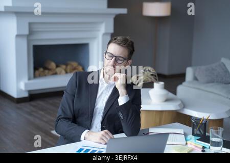 Business consultant reviewing charts and documents in contemporary living room office Stock Photo