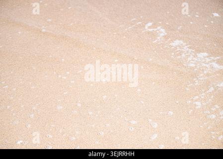 Top down view of wet sand texture left by ocean waves on the shoreline Stock Photo