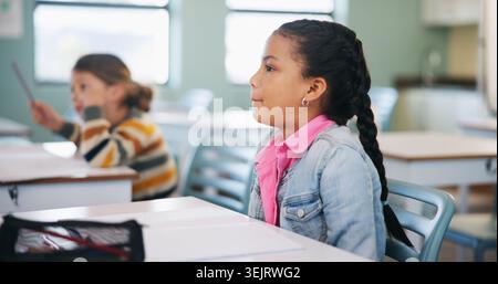 Child, learning and lesson in classroom, education and listening to teacher for academic development. Elementary school, students and kids with Stock Photo