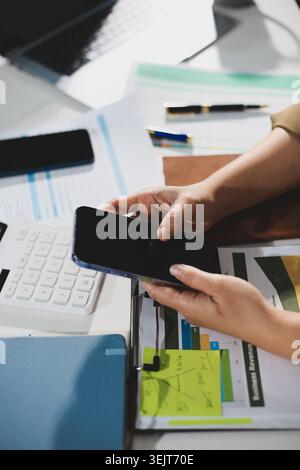 Young Asian woman working late at her desk, having a video call or online meeting with a laptop, analyzing data and managing business financials in an Stock Photo