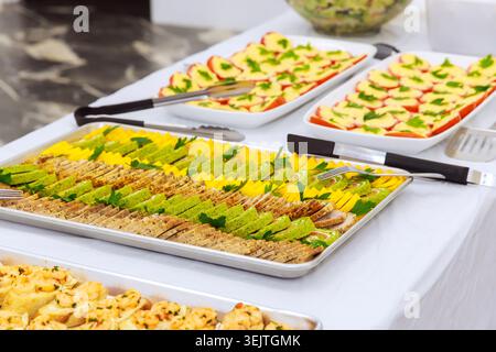 Food items are set on table, various snacks for guests at social event in hall. Stock Photo