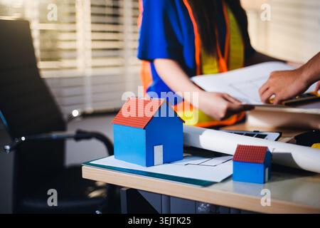 Two technicians inspect server racks in data center with tablet and fiber optic cable. Engineer and specialist discuss maintenance work in data center Stock Photo