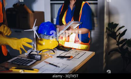Two technicians inspect server racks in data center with tablet and fiber optic cable. Engineer and specialist discuss maintenance work in data center Stock Photo