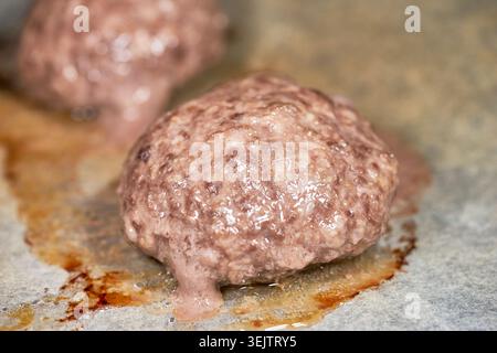 cooking Hamburg steak. One captures a patty sizzling in its juices, and the other features a patty with perfectly melted cheese. Stock Photo