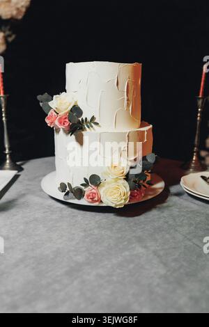 White textured cake with soft roses and greenery Stock Photo