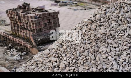 Close-up of crushed stone and paving blocks at a construction site, highlighting roadwork materials, infrastructure and urban development. Stock Photo
