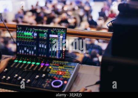 Lighting technician operator working on mixing console, workplace during live event, stage concert show broadcast, light mixer controller panel, sound Stock Photo