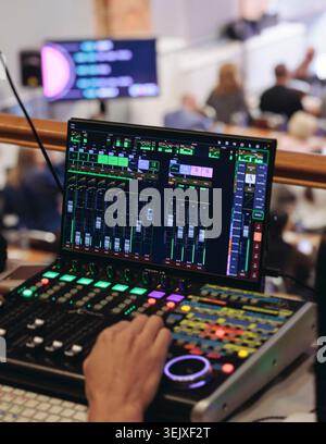 Lighting technician operator working on mixing console, workplace during live event, stage concert show broadcast, light mixer controller panel, sound Stock Photo