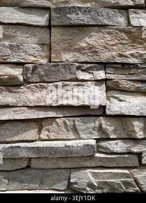 High-resolution background texture of a natural stone wall finish. Modern slate rock cladding masonry for architectural, building facade, exterior and Stock Photo