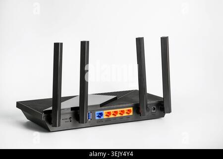 Black wireless router with four antennas and multiple LAN ports isolated on white background. Concept of home internet, networking, broadband connecti Stock Photo