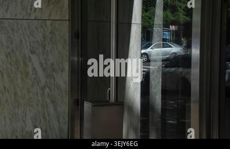 A parked car reflected in an office building window Stock Photo