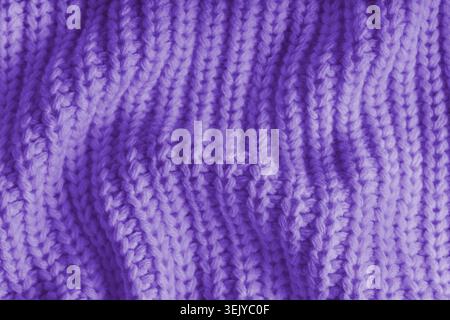 Close up, macro of crumpled purple knitted fabric with visible wrinkles, folds and soft waves. Soft wool texture with detailed stitches and creases, n Stock Photo