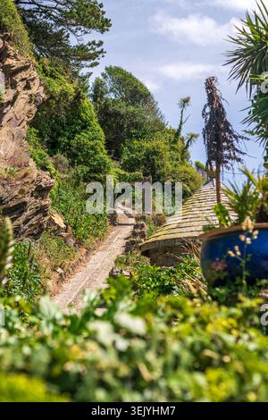 Stone Pathway and Archway Through Lush Hillside Garden in Polperro, Cornwall Stock Photo