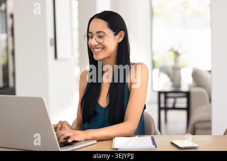 Woman working remotely on laptop at home Stock Photo