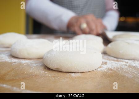 Baking dough on a wooden surface in kitchen at night Stock Photo