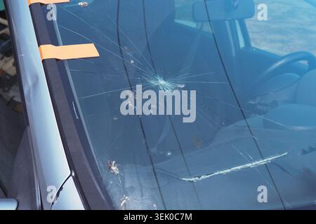 Windshield with cracks in a parked car at daytime Stock Photo