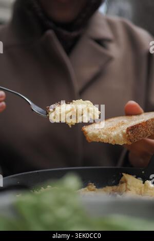 Scrambled Eggs on Toast Being Served With Spoon for Casual Homemade Breakfast Stock Photo