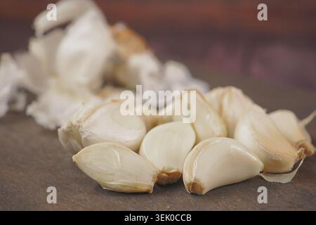 Fresh garlic cloves on a wooden surface ready for cooking Stock Photo