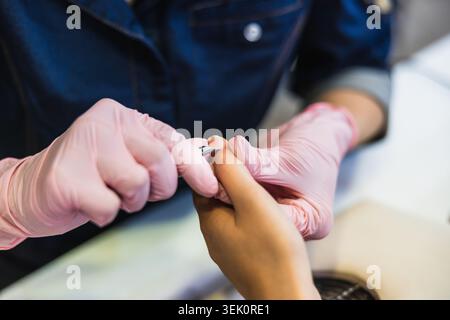 Nail technician performing manicure in beauty salon Stock Photo