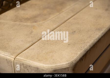 Detailed view of a textured, aged leather car seat with visible dirt and discoloration, highlighting wear and tear over time Stock Photo