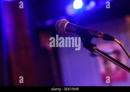 Microphone standing on a stage, ready for a live musical performance or event, creating an atmosphere perfect for entertainment and concert photograph Stock Photo