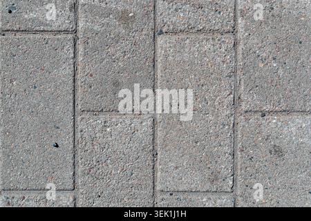 pedestrian path from top down, pebbles and sand on weathered pavement bricks, vertical lines Stock Photo