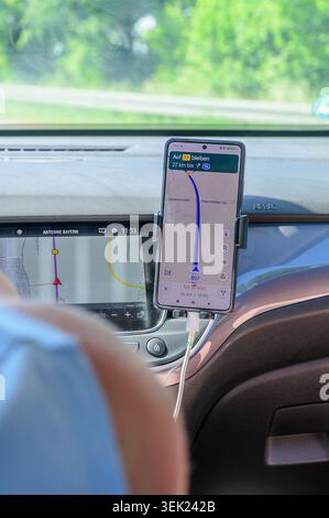 Augsburg, Germany — May 31 2026: Smartphone mounted on a car dashboard displaying a Google Maps navigation route along Bundesstrasse 17 next to the bu Stock Photo