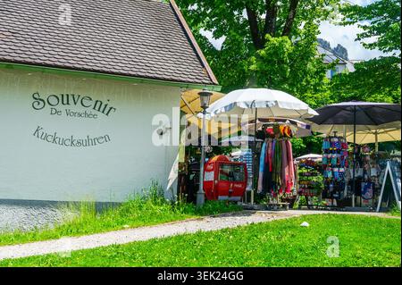 Hohenschwangau, Germany - May 31 2026: An outdoor souvenir shop stand with umbrellas displaying clothing, gifts, and cuckoo clocks text written on the Stock Photo