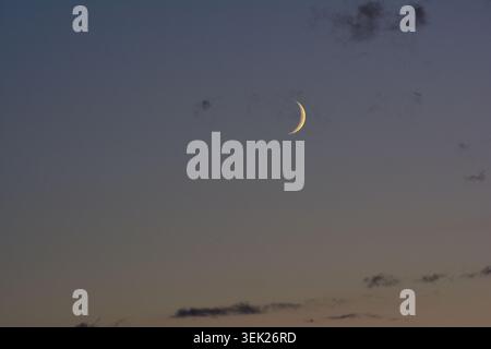 Close-Up View of a Brilliant Crescent Moon in a Dusky Twilight Sky Stock Photo