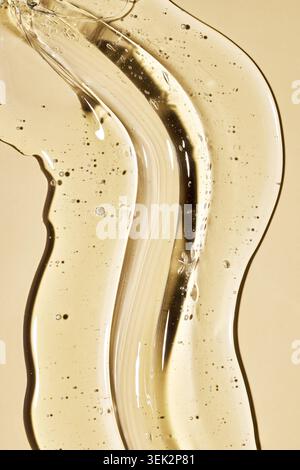 Clear yellow cosmetic gel with bubbles creating a flowing, wavy texture for beauty and scientific concepts Stock Photo