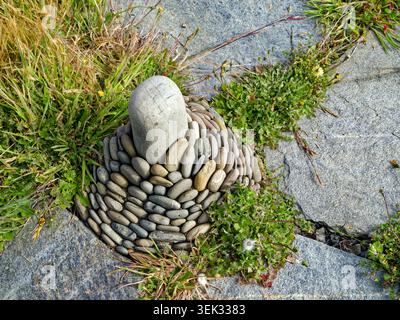 A concentric arrangement of stones is on a slate walking path Stock Photo