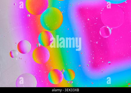 Bright multicolored macro texture with floating oil spheres over neon rainbow gradient backdrop Stock Photo