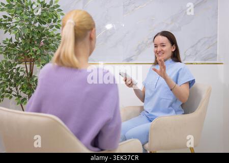 Cosmetologist consulting client, discussing beauty treatments and services in a modern salon, offering expert advice, professional care, and personali Stock Photo