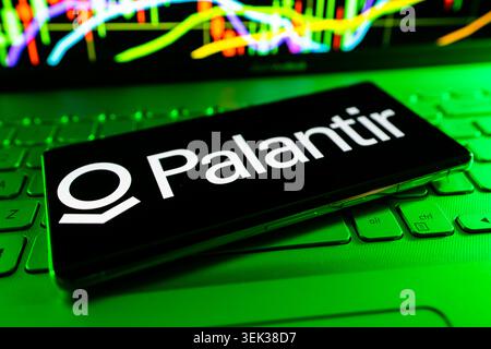 Palantir Logo Displayed On Mobile Phone With Stock Market Performance Chart Background And Trading Graph Interface Stock Photo
