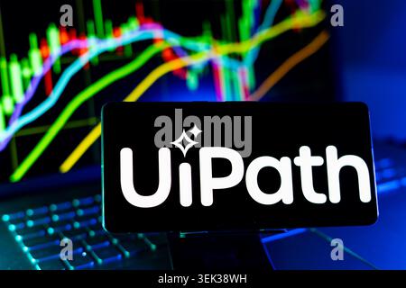 UiPath Logo Displayed On Mobile Phone With Stock Market Performance Chart Background And Trading Graph Interface Stock Photo
