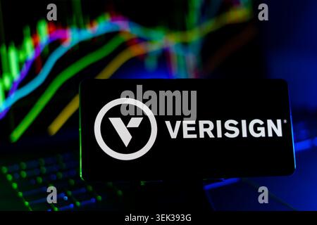 Verisign Logo Displayed On Mobile Phone With Stock Market Performance Chart Background And Trading Graph Interface Stock Photo