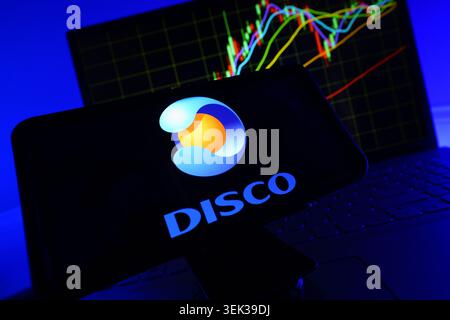 DISCO Logo Displayed On Mobile Phone With Stock Market Performance Chart Background And Trading Graph Interface Stock Photo