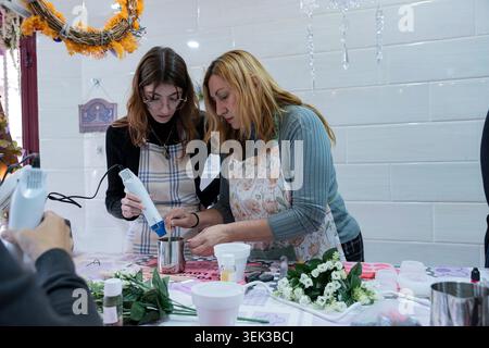 Women concentrating, creating handmade candles in a creative workshop setting Stock Photo
