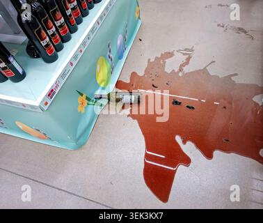VORONEZH, Russia - April 25, 2026 A bottle of red wine has broken on the floor of a supermarket. Dark red liquid is spilled around the bottle, showing Stock Photo