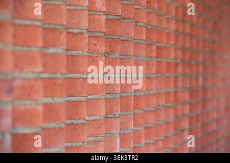 Perspective view of red brick wall with geometric pattern and selective focus Stock Photo
