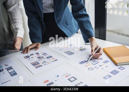 The development team brainstorms user interfaces and experience designs for the graphical UX UI graphics prototype for mobile applications Stock Photo